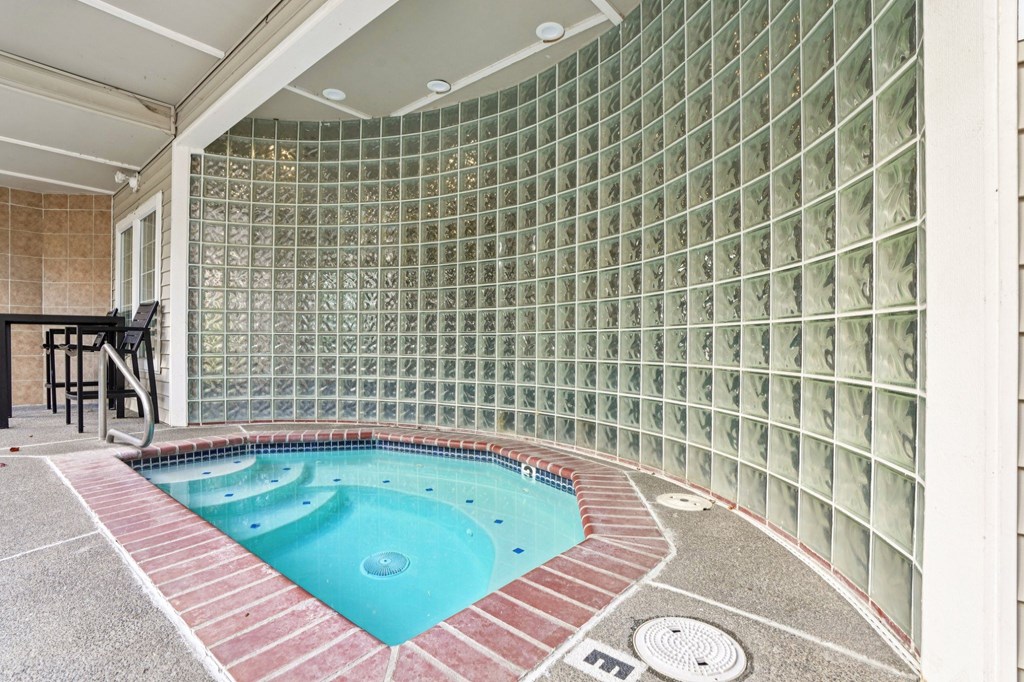 A hot tub with a tiled wall.