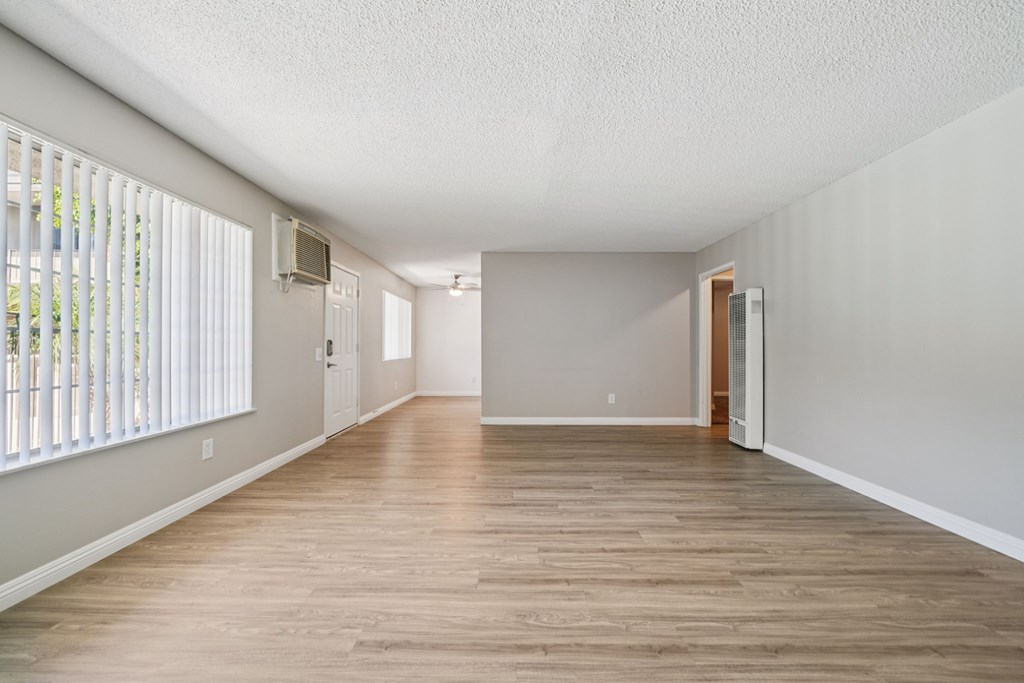 A living room with wooden floors and white walls.