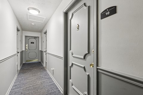 A hallway with a door on the right and a sign on the wall.