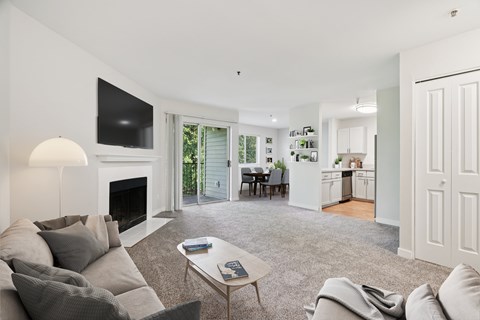 A living room with a grey couch and a fireplace.