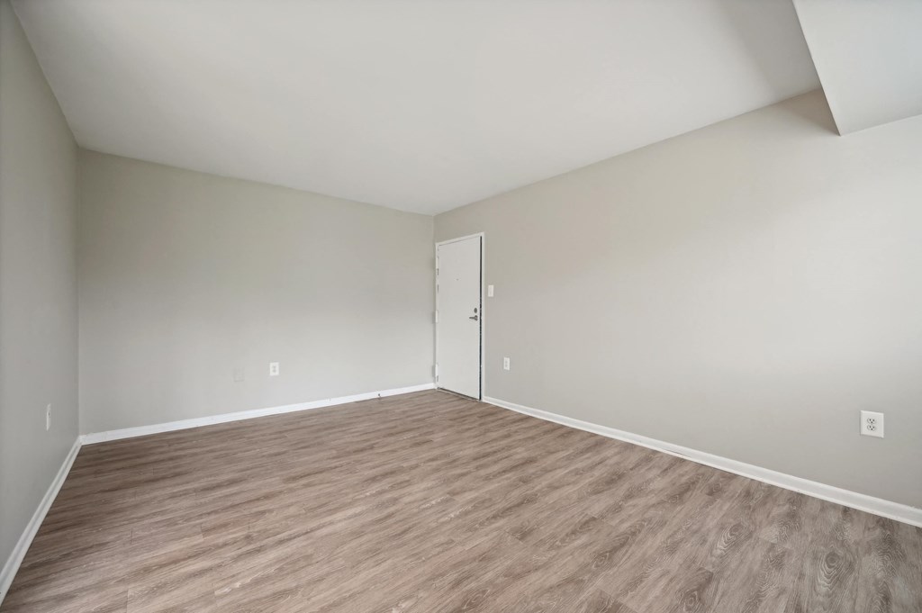 an empty room with white walls and wood flooring at ReNew Odenton