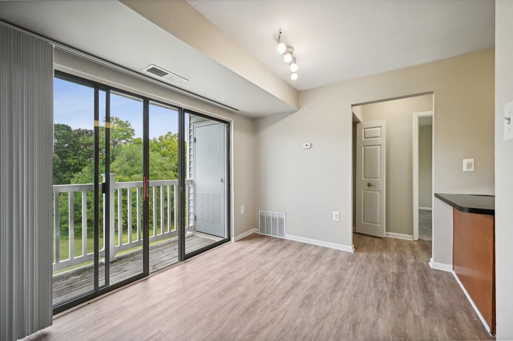 an empty living room with large windows and a balcony at ReNew Odenton