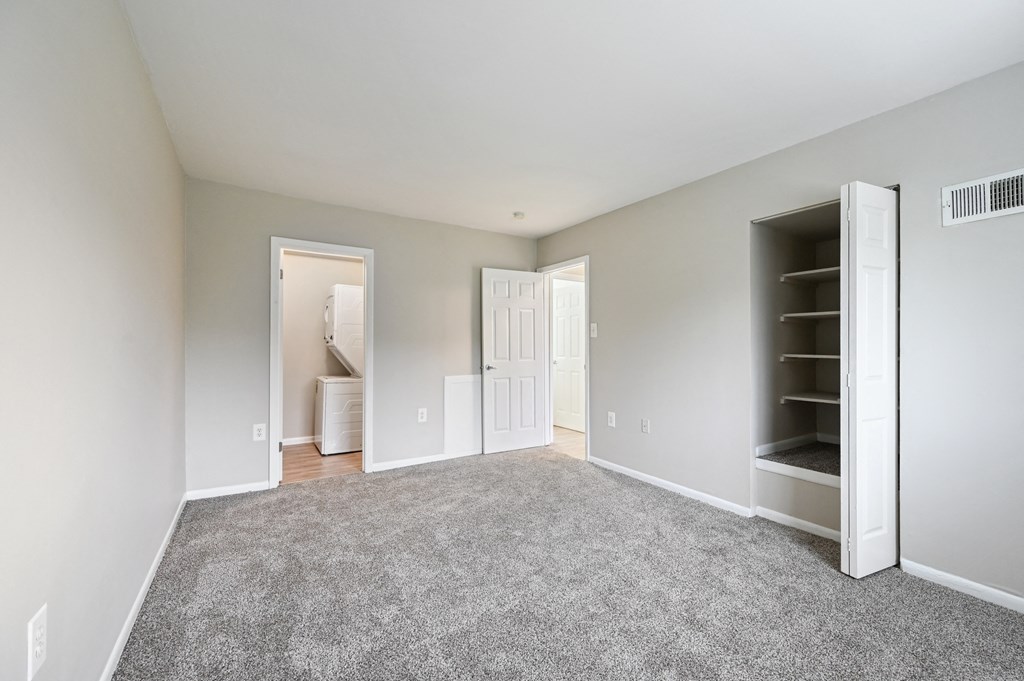 an empty bedroom with carpet and a closet at ReNew Odenton