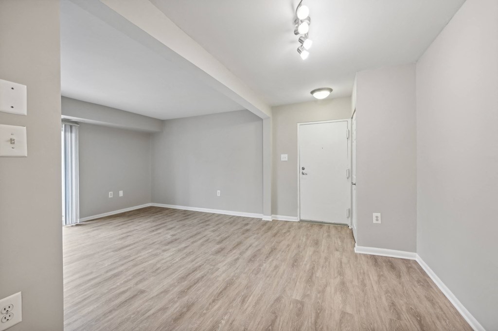 an empty living room with white walls and wood flooring at ReNew Odenton