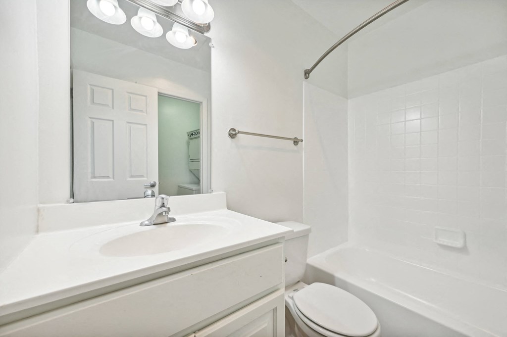 a white bathroom with a sink and a mirror at ReNew Odenton