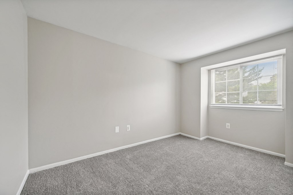 an empty room with carpet and a window  at ReNew Odenton