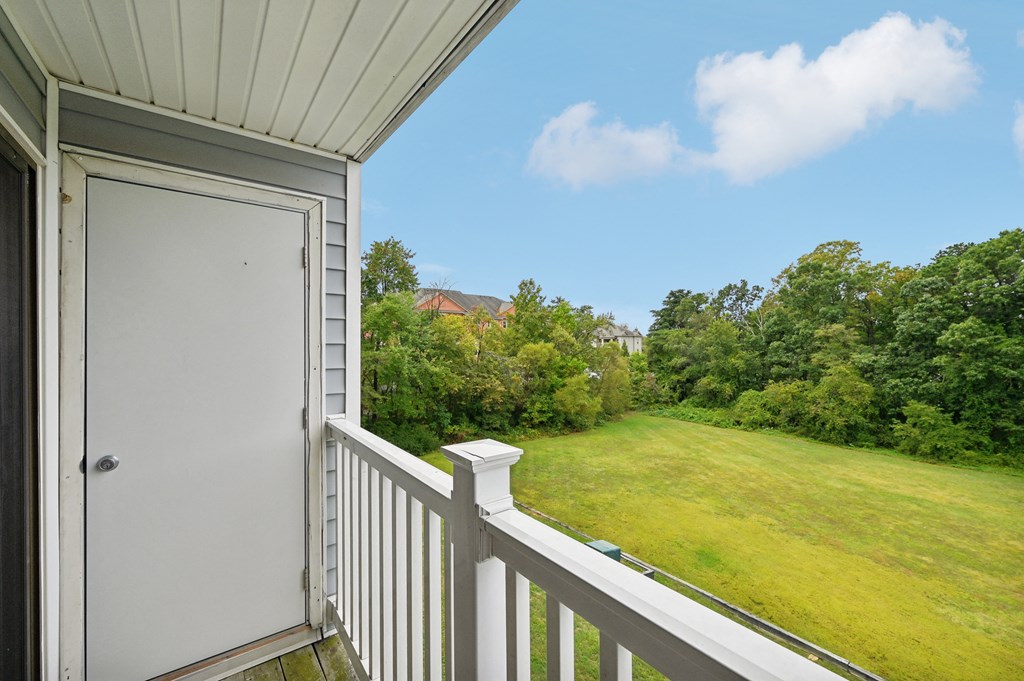 the view from the balcony of a home overlooking a grassy field and a door at ReNew Odenton
