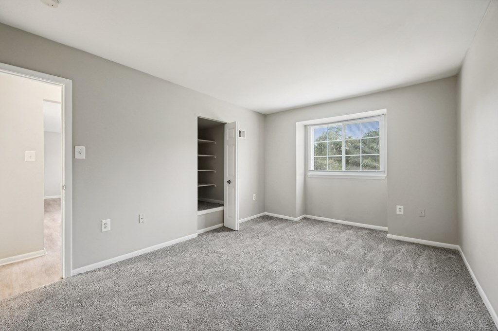 an empty room with carpet and a door to a closet at ReNew Odenton