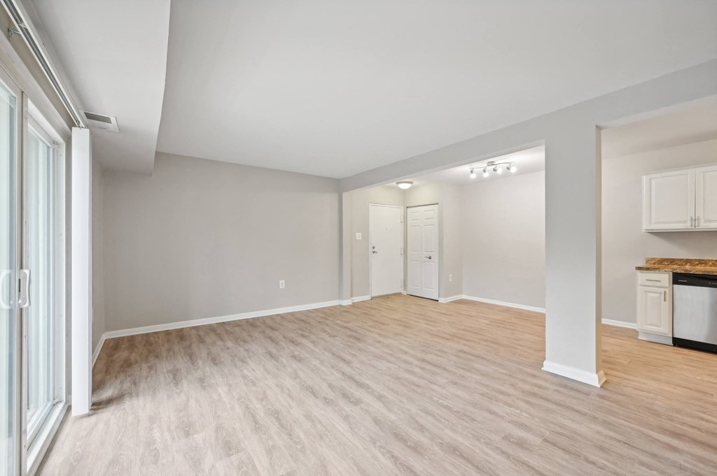 the living room and kitchen of an empty house with wood flooring at ReNew Odenton