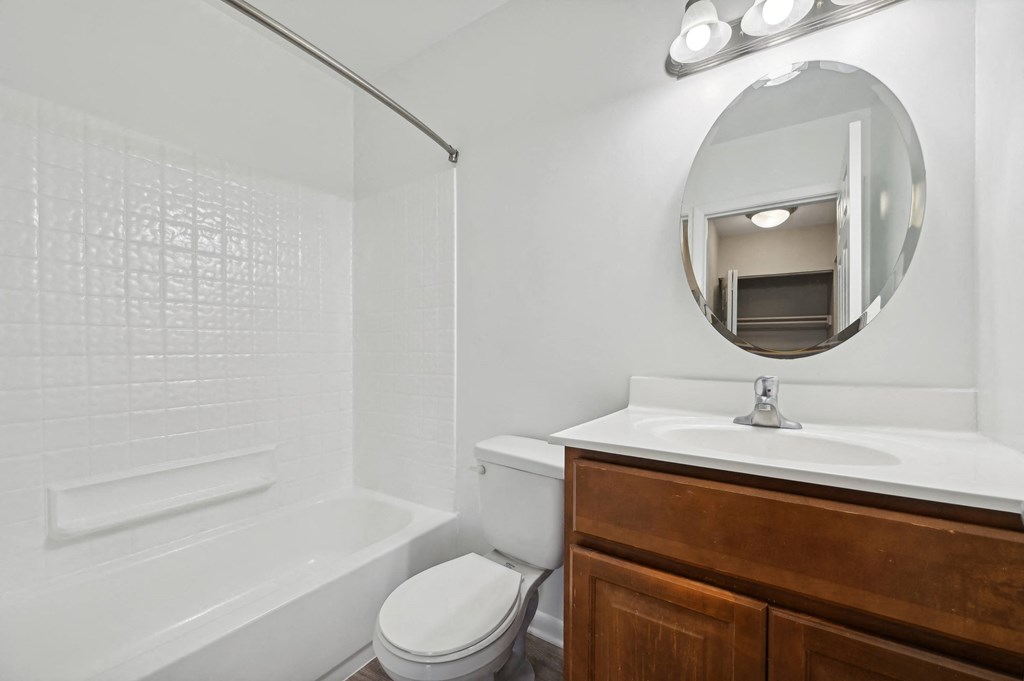 a bathroom with a toilet and sink with mirror and shower at ReNew Odenton