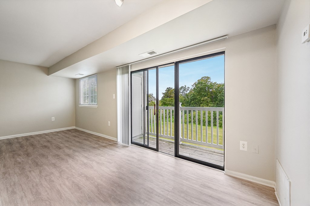 an empty living room with sliding glass doors to a balcony at ReNew Odenton