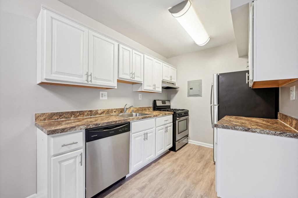 a renovated kitchen with white cabinets and stainless steel appliances at ReNew Odenton