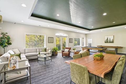 A modern living room with a wooden table and grey chairs.