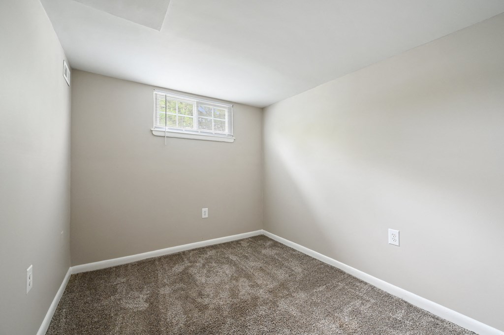 an empty room with carpet and a window at ReNew Odenton