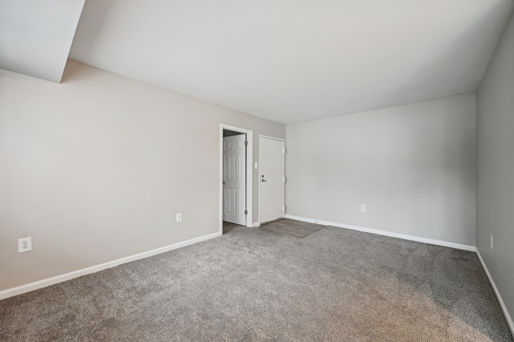 an empty room with carpet and a door to a closet at ReNew Odenton