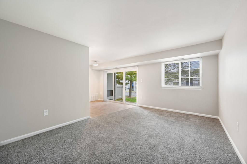 an empty living room with a window and a door to a yard at ReNew Odenton