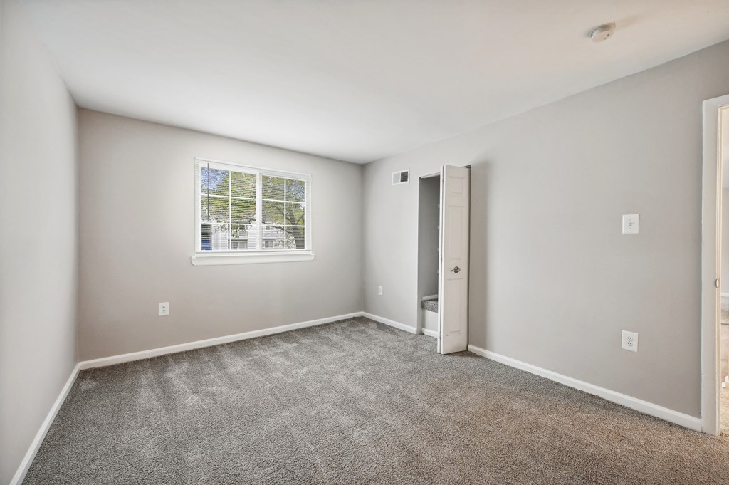 Empty room with white door and carpeted floor and window at ReNew Odenton