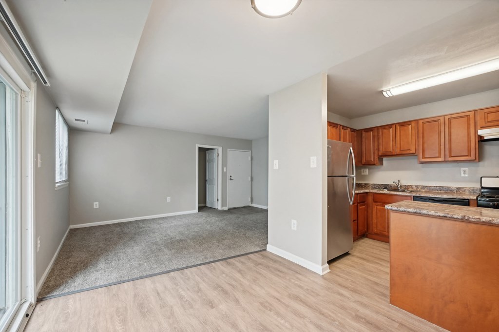 a kitchen and living room with wood flooring and a stainless steel refrigerator at ReNew Odenton
