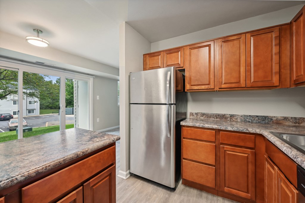 a kitchen with wooden cabinets and a stainless steel refrigerator at ReNew Odenton