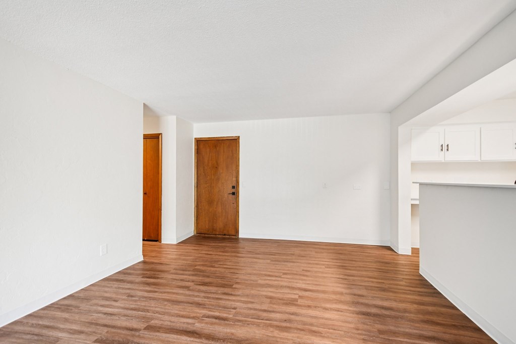 A room with wooden floors and two doors.