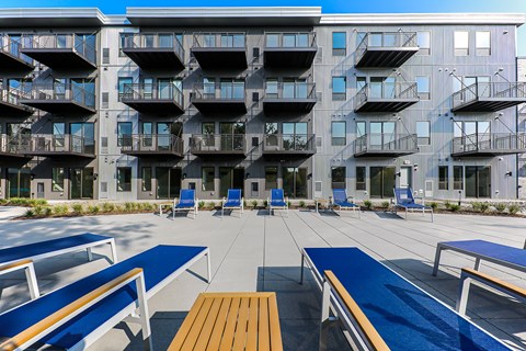 Pool deck with blue lounge chairs and seating at Pure Lowry Apartments, Minneapolis, Minnesota