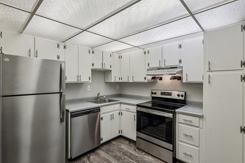 A kitchen with white cabinets and stainless steel appliances.