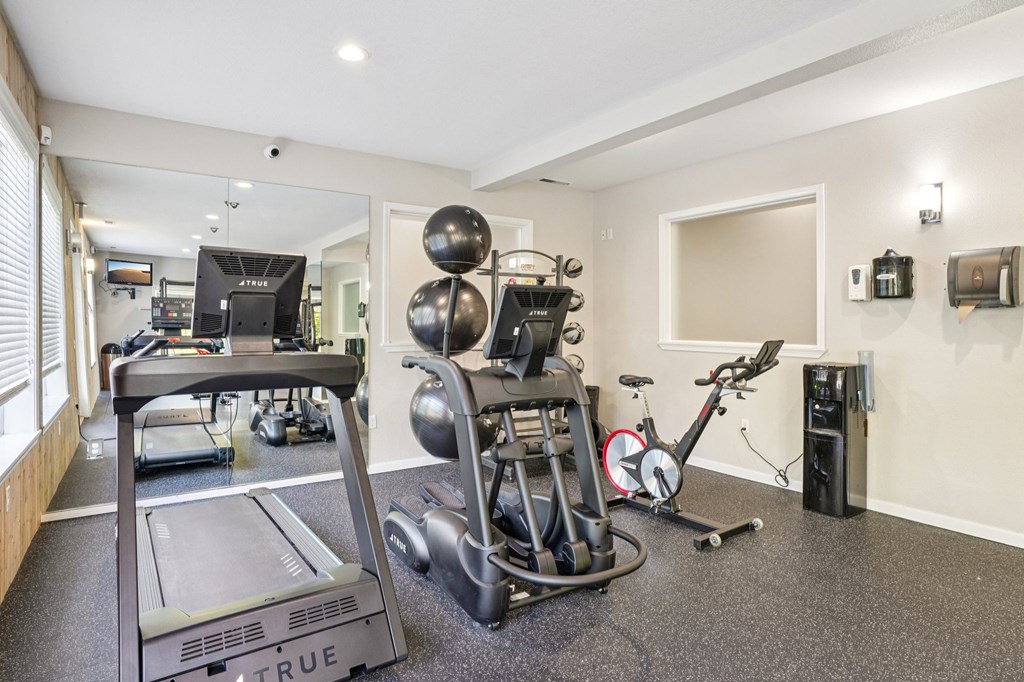 Fitness center with a treadmill, stationary bike, and other exercise equipment.