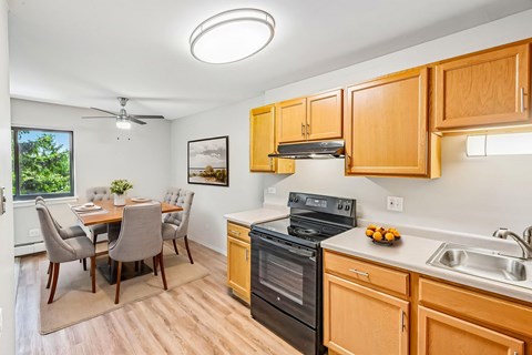 A kitchen with wooden cabinets and a black oven.