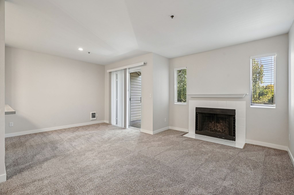 A living room with a fireplace and a sliding door.