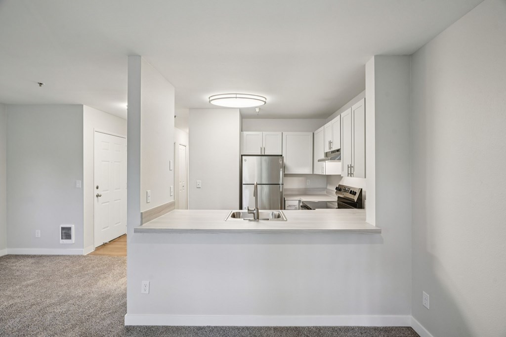 A kitchen with white cabinets and a countertop.