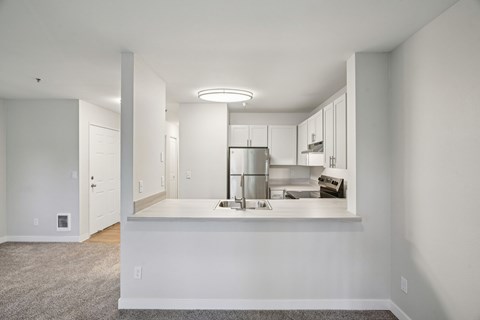 A kitchen with white cabinets and a countertop.
