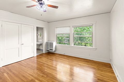 Bedroom with hardwood floors and window view at Forestry Court Apartments, Portland, 97210