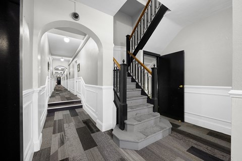 A long hallway with a staircase on the right at Pleasant Oak Apartments, Oak Park, Illinois