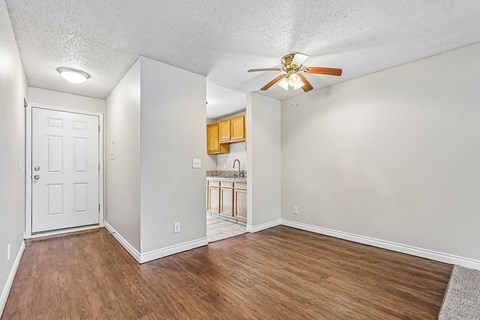 A room with a ceiling fan and wooden flooring.