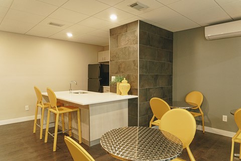 A kitchen with a table and chairs.