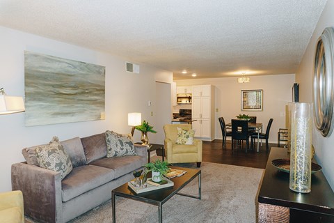 A living room with a couch, coffee table, and a painting on the wall.