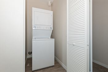a small laundry room with a washer and dryer and a closet