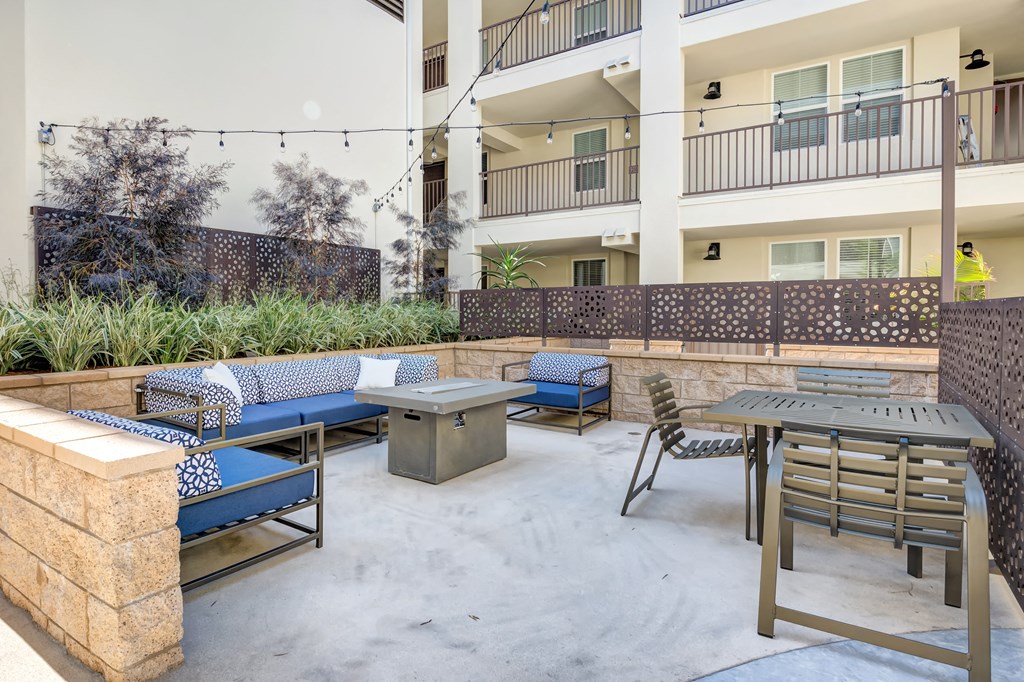 a patio with a table and chairs and a building in the background