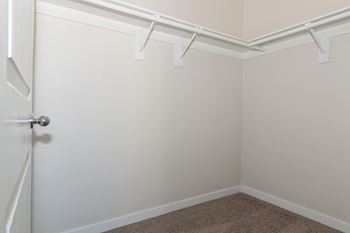 an empty room with white walls and a white closet
