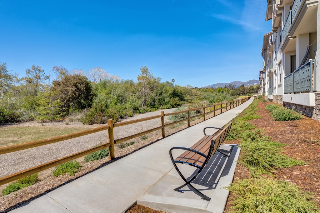 a bench sits on the side of a building with trees in the background