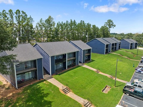 a row of blue houses with a grassy area at Alcovy Terrace, Covington, Georgia, 30014