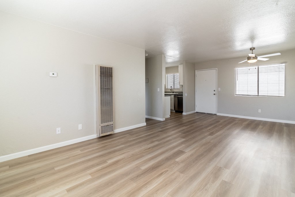 an empty living room with hardwood flooring and a kitchen at Alturas Paso Robles Apartment Homes, California