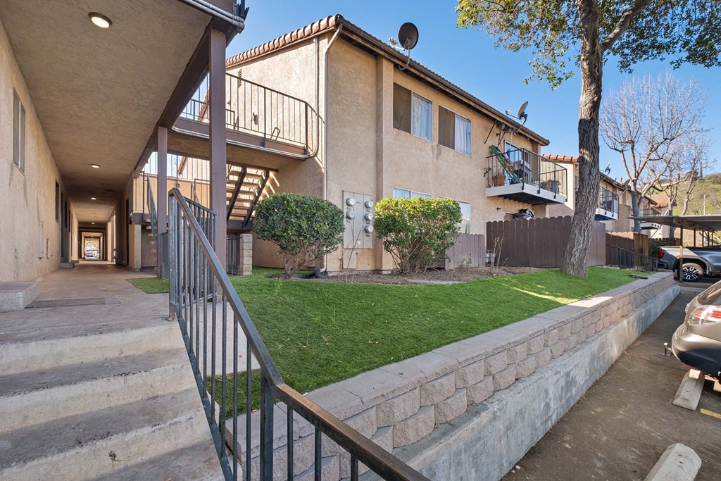 a building with a staircase and a yard in front of it at Alturas Paso Robles Apartment Homes, Paso Robles, CA, 93446