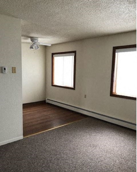 an empty room with a wood floor and a window an empty room with a wood floor and a window at Woodridge Apartments, Kenai, Alaska