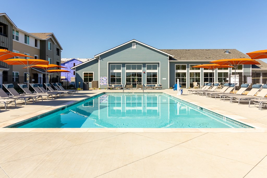 a swimming pool with chairs and umbrellas next to a building at Arrive Paso Robles, California, 93446