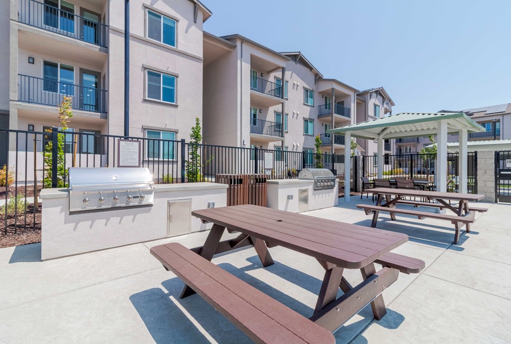 A picnic table is in the foreground of a courtyard with apartment buildings in the background.