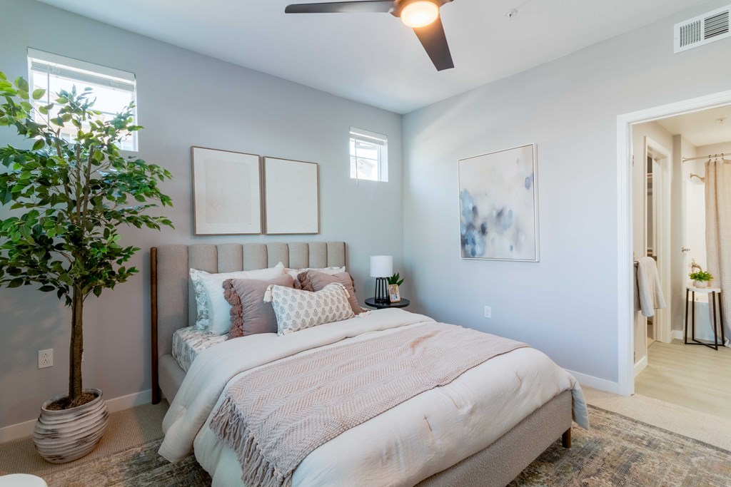 A bedroom with a large bed and a ceiling fan.