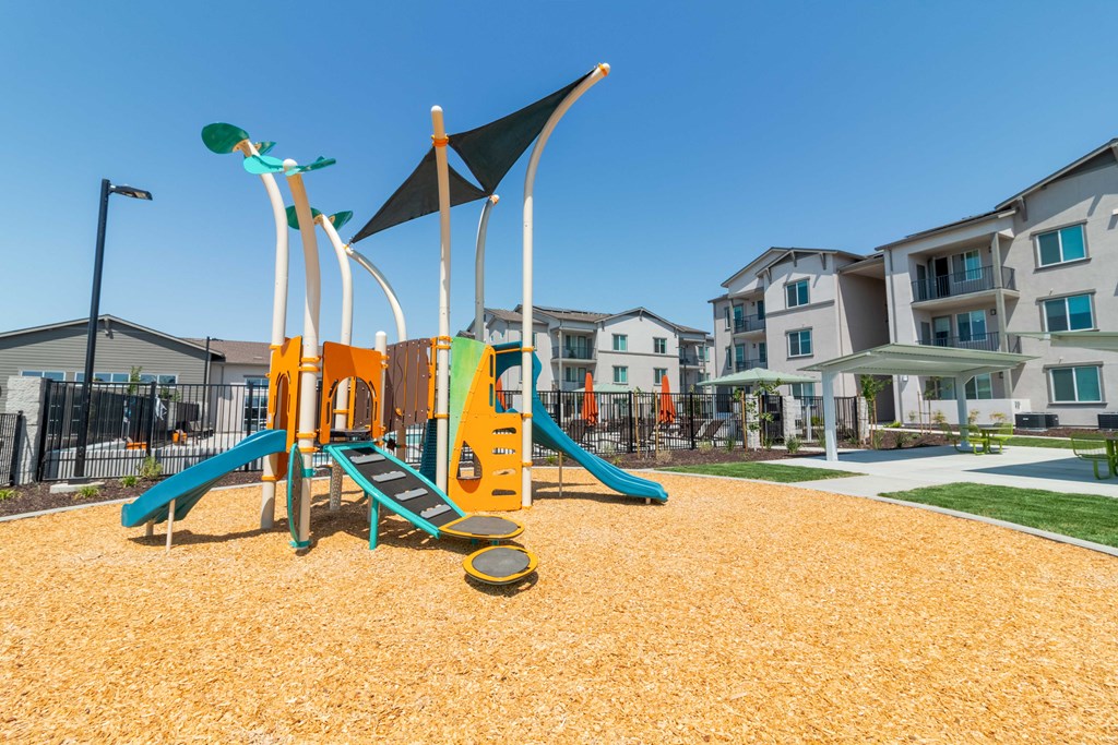 Kids playground with slides and apartment buildings in the background