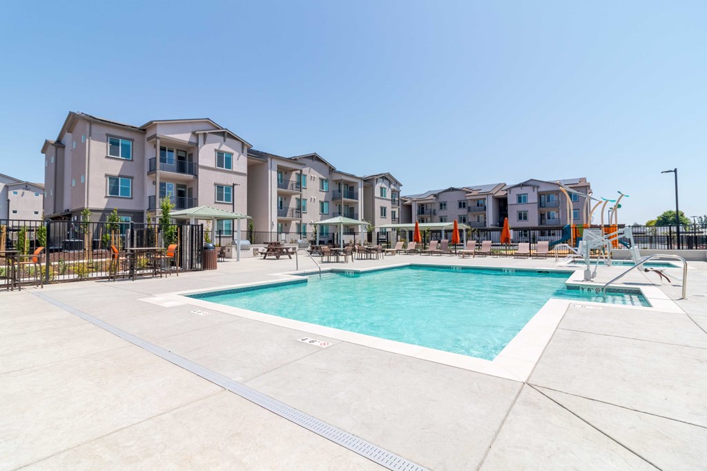 A large swimming pool in front of apartment buildings.