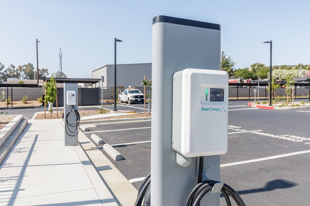 A charging station for electric vehicles is shown in a parking lot.